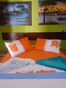 een bed met oranje en witte kussens erop bij Aloha Noronha Hostel in Fernando de Noronha