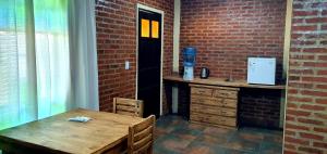 Habitación con mesa de madera y pared de ladrillo. en La Maína Uribe Posada, en Uribelarrea
