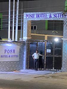 ラゴスにあるPosh Hotel and Suites Victoria Islandのホテルの出入口に立つ男