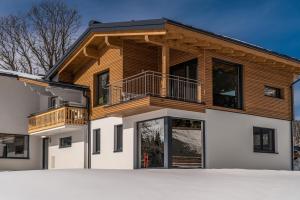 a wooden house with a balcony on top of it at Appartement Ahorn in Ramsau am Dachstein