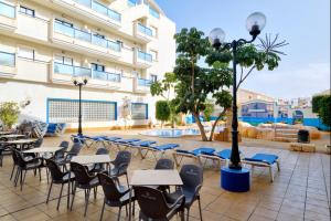 ein Innenhof mit Tischen und Stühlen vor einem Gebäude in der Unterkunft Playamarina II Rooftop Apartment in Orihuela