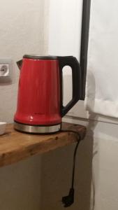 une bouilloire à thé rouge assise sur une étagère en bois dans l'établissement B&Bio la casa di Giò, à Osimo