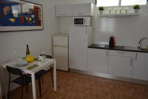 - une cuisine blanche avec une table et un réfrigérateur blanc dans l'établissement Maspalomas Studio, à Maspalomas