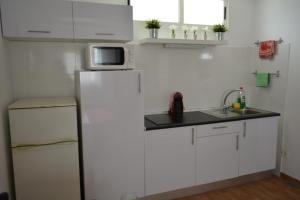 una cucina bianca con frigorifero e forno a microonde di Maspalomas Studio a Maspalomas Altre 2 foto