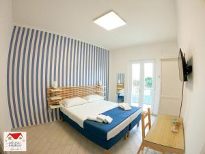 una camera da letto con un letto con una parete a strisce di Antonio&Maria's home a Pompei