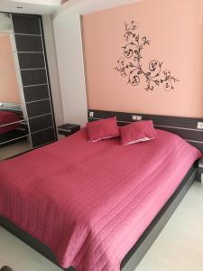 una camera con letto rosa e lenzuola rosa di Apartment 33 in Hotel Iceberg a Borovets
