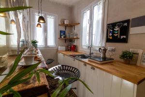 cocina con encimera y fregadero y algunas ventanas en B&Bio la casa di Giò, en Osimo