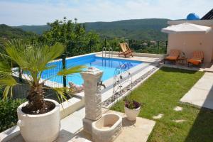 a backyard with a swimming pool and a house at Vila Pelinovo in Kotor
