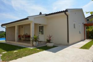 a white house with a patio and a table at Vila Pelinovo in Kotor