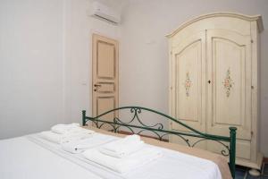 a bedroom with a bed with white sheets and a door at Agriturismo Agrimaccari Marzamemi-Vendicari - Esperienza autentica siciliana in Marzamemi