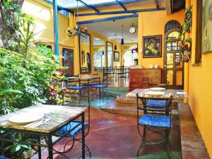 a restaurant with tables and chairs and plants at Hotel Casa 69 in San José