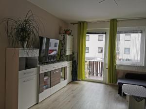 ein Wohnzimmer mit einem TV und einem Balkon in der Unterkunft Nina´s Appartement Bad Mitterndorf in Bad Mitterndorf