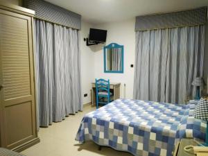 a bedroom with a blue and white bed and a table at Hotel Pineda Playa in Noja