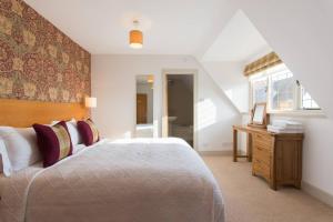 a bedroom with a bed and a desk and a window at Sandford Country Cottages in Newport-On-Tay