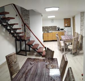 a living room with a table and a spiral staircase at Casa Savianu Cavnic in Cavnic