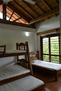 Habitación con 3 literas y ventana. en Finca el Lunar, en Honda