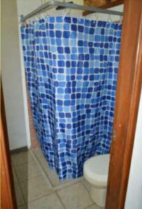 cortina de ducha azul en el baño con aseo en Finca el Lunar, en Honda