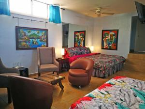 圣何塞Hotel Casa 69的一间卧室配有一张床、一张沙发和一把椅子