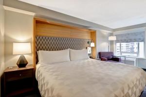 a bedroom with a large bed and a large window at Holiday Inn - Ottawa Dwtn - Parliament Hill, an IHG Hotel in Ottawa