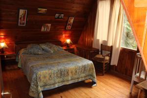 1 dormitorio con 1 cama en una cabaña de madera en Cabaña Llavu Lemu en San Carlos de Bariloche