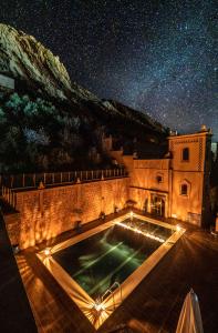 un edificio con piscina di notte di Hotel Riad Bahammou ad Aït Idaïr