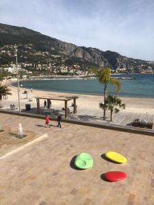 a group of frisbees on a beach with people walking at CASA VACANZA IN COSTA AZZURRA in Menton