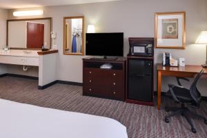 a hotel room with a bed and a desk with a television at Spark By Hilton North Little Rock in North Little Rock