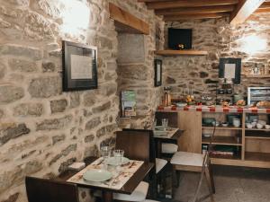 un restaurante con 2 mesas y una pared de piedra en PR Campanas de San Juan en Santiago de Compostela