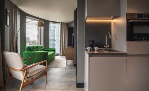 a kitchen and a living room with a green couch at The Gate London City in London
