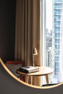 a table with a lamp on it next to a window at The Gate London City in London