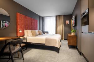 a hotel room with a bed and a desk at The Gate London City in London +37 photos