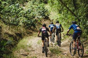 a group of people riding bikes down a dirt trail at Hotel Restaurante Selva Negra in Turbaco