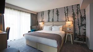 a hotel room with a large bed and a window at Holiday Inn Manchester - City Centre by IHG in Manchester +37 photos