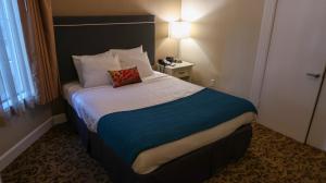 a bedroom with a white bedspread and a white comforter at City Center Inn and Suites in San Francisco