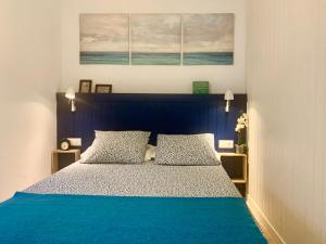 1 dormitorio con 1 cama azul y 2 almohadas en Casa Marina, en Frigiliana
