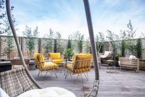a patio with yellow chairs and a table and chairs at The Gate London City in London