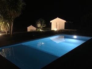 a blue swimming pool at night with a house at GRANARY'S HOUSE in Sete Cidades