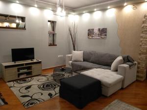 a living room with a couch and a tv at Home Spot Nafplio in Nafplio