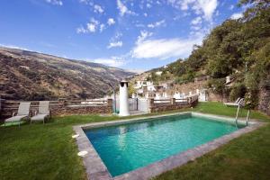 a swimming pool in the yard of a house at Estrella de las Nieves in Pampaneira
