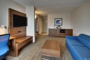 a hotel room with a couch and a flat screen tv at Holiday Inn Express Atlantic City W Pleasantville by IHG in West Atlantic City