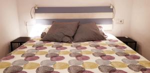um quarto com uma cama com um edredão roxo e amarelo em Apartamento acogedor a 3 minutos de la playa em Blanes
