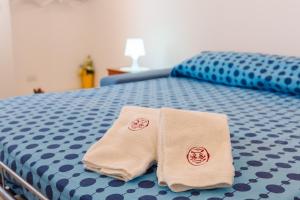 2 asciugamani posti sopra un letto di Iolanda Vacanze a Lucugnano