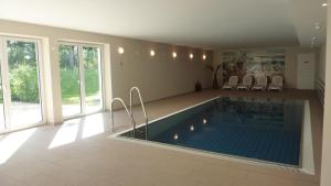 a swimming pool in a living room with chairs around it at Zum Inselparadies, Haus Meeresblick in Baabe