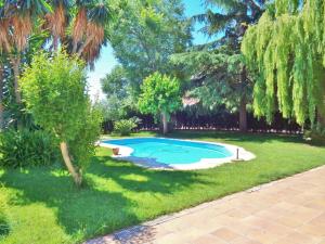 a small swimming pool in a yard with trees at Belvilla by OYO Casa Jaume in San Pol de Mar