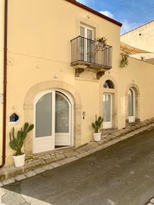 een gebouw met een balkon en potplanten erop bij Il Canale Design House in Ragusa