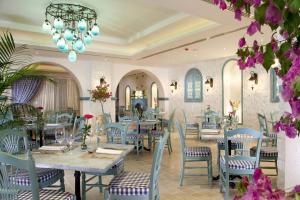 a restaurant with tables and chairs and a chandelier at Sunrise Arabian Beach Resort in Sharm El Sheikh