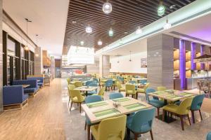 a dining room with tables and chairs and a restaurant at Holiday Inn Kunshan by IHG in Kunshan