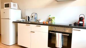 a kitchen with a refrigerator, microwave, sink and dishwasher at Panda Stella in Zaventem