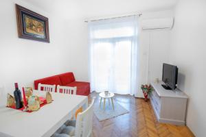 a living room with a white table and a red couch at Ana Guesthouse in Dubrovnik