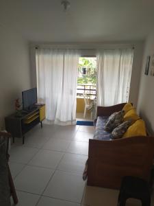 a bedroom with a bed and a television and a window at Reserva dos Corais in Cabo de Santo Agostinho